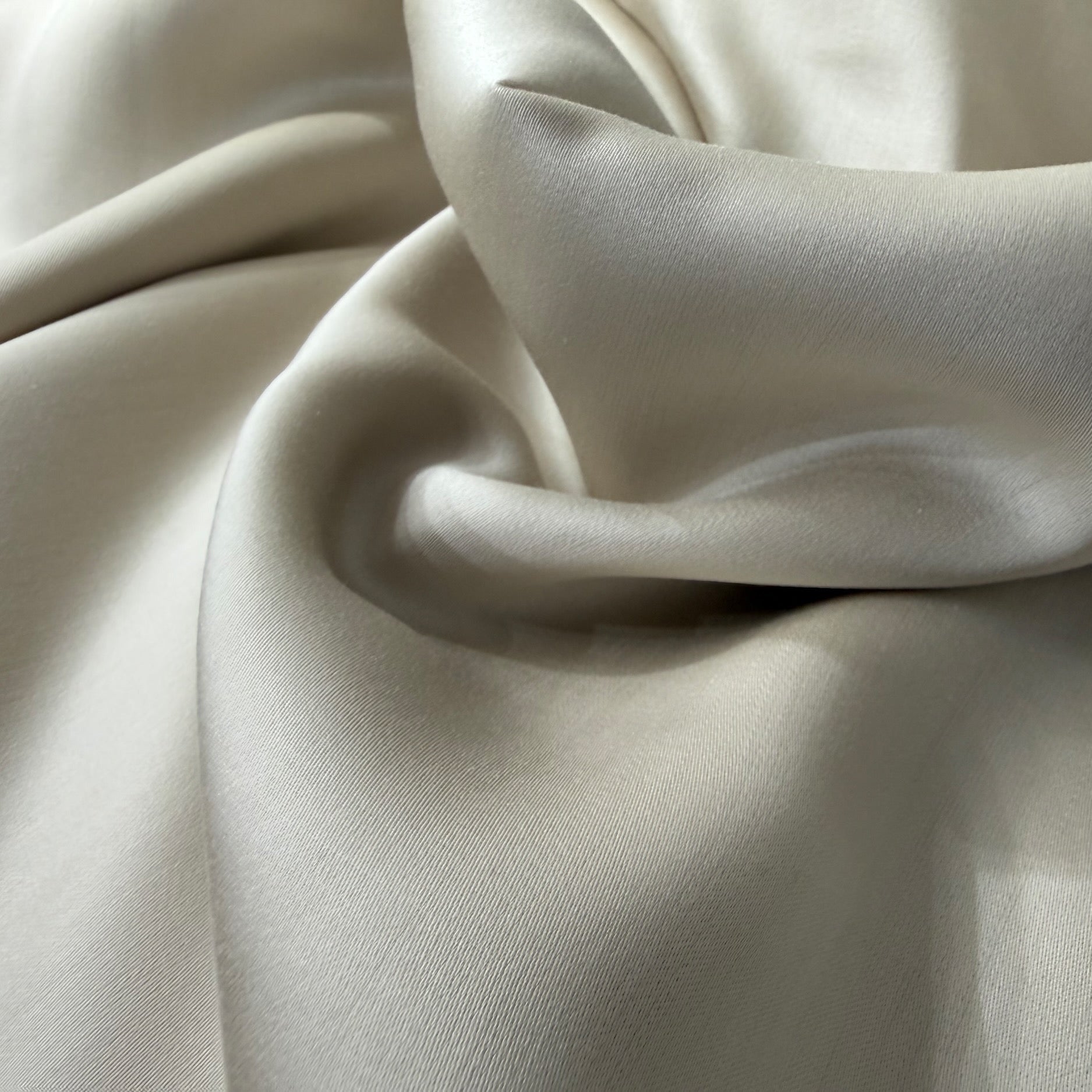 Nordhavn Living Aurora Satin Bettwäsche in Sandbeige (Drift Light): Nahaufnahme der voluminösen Falten, die das elegante Lichtspiel und den weichen Fall des Tencel-Satins unterstreichen.