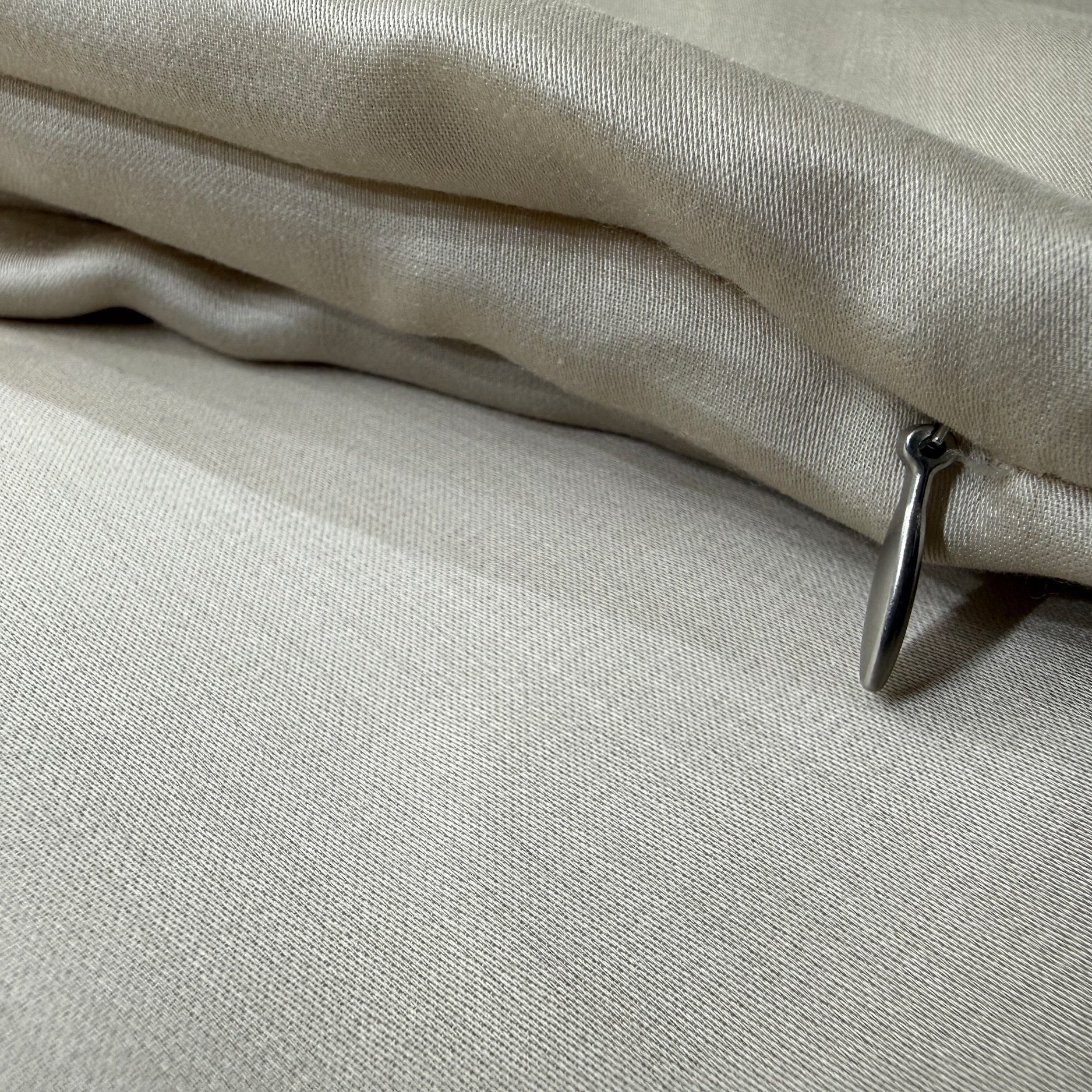 Nordhavn Living Aurora Satin Bettwäsche in Sandbeige (Drift Light): Detailaufnahme des hochwertigen, verdeckten Reißverschlusses mit elegantem Metall-Zipper. #Farbe_Drift Light