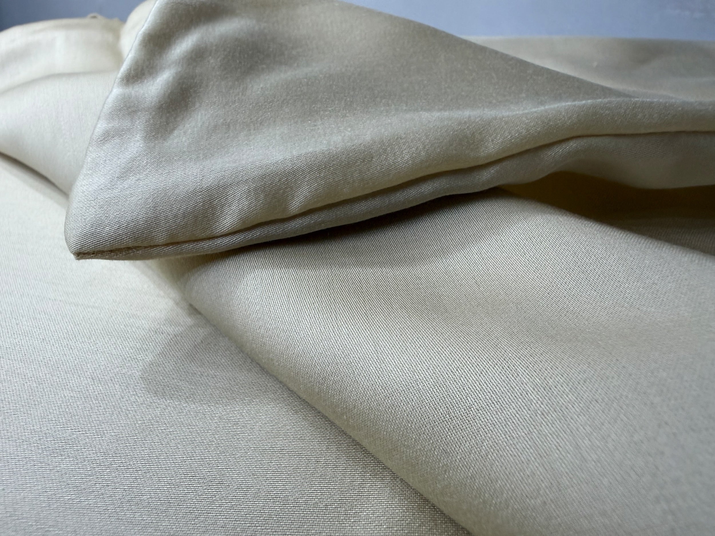Nordhavn Living Aurora Satin Bettwäsche in Hellem Greige (Harvest Dust): Detailansicht der weich übereinanderliegenden Stofflagen, die den natürlichen Fall und den pudrigen, sanften Glanz des Tencel-Satins unterstreichen.
