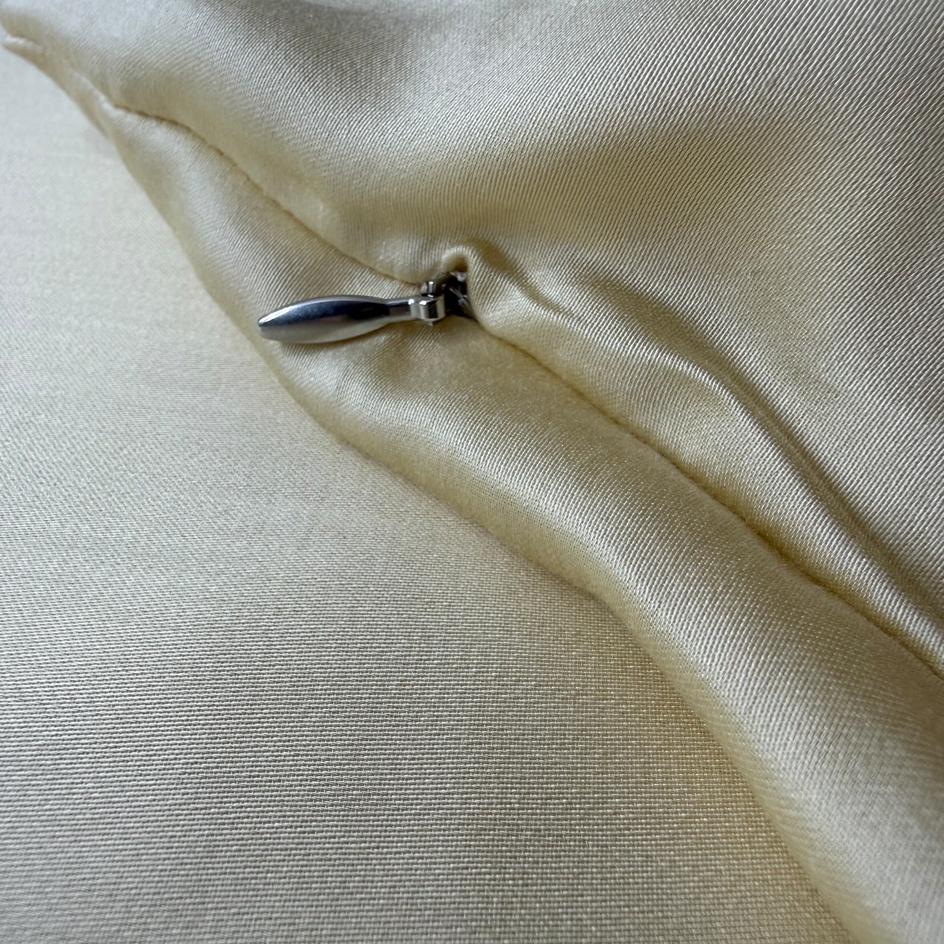 Nordhavn Living Aurora Satin Bettwäsche in Hellem Greige (Harvest Dust): Detailansicht des verdeckten Reißverschlusses mit edlem Metall-Zipper, der diskret unter einer weichen Stofffalte liegt.