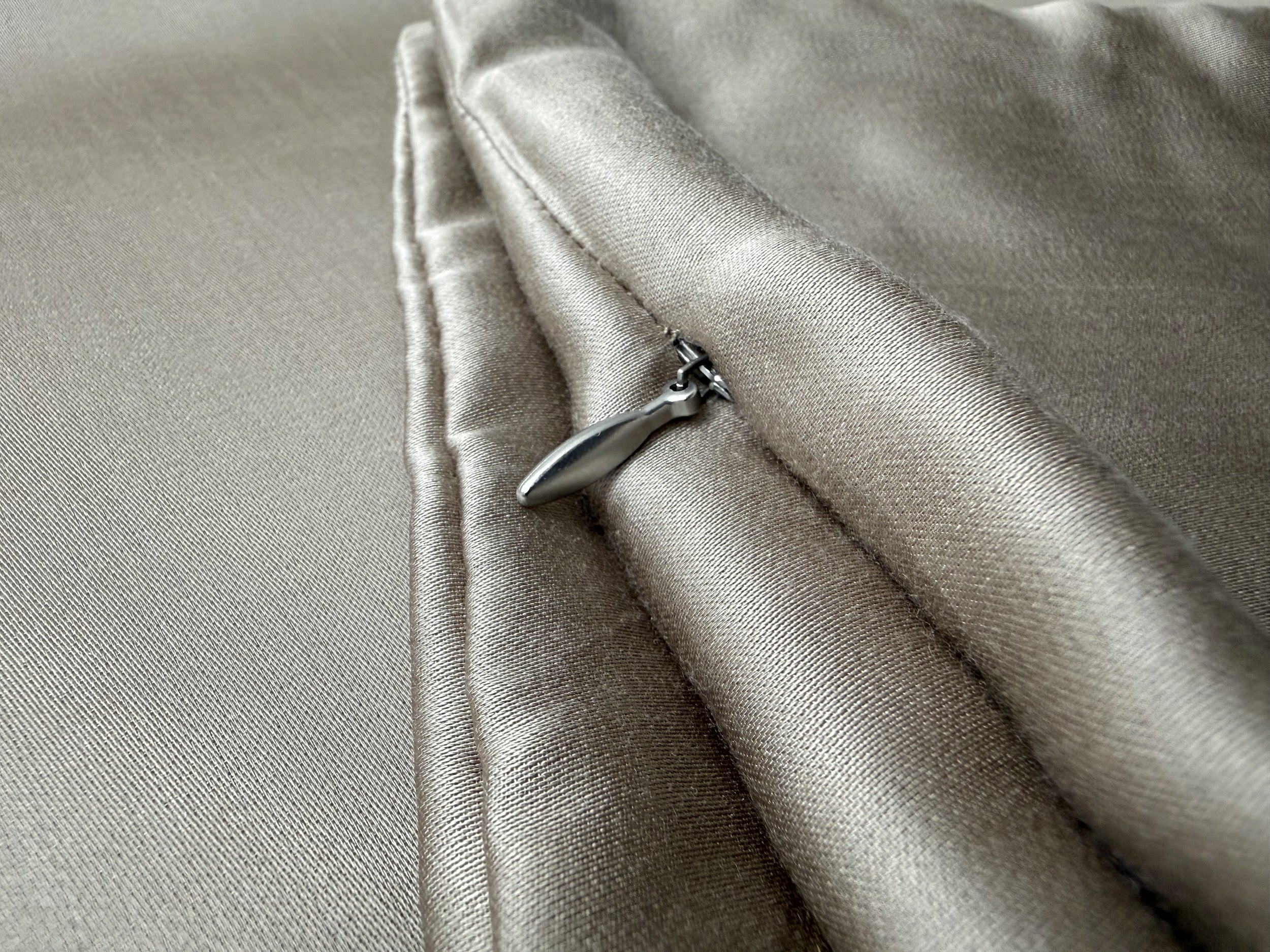 Nordhavn Living Aurora Satin Bettwäsche in Warmem Lehmgrau (Still Clay): Detailfokus auf den eleganten Reißverschluss-Zipper und die akkurate Nahtführung entlang der Stoffkante.